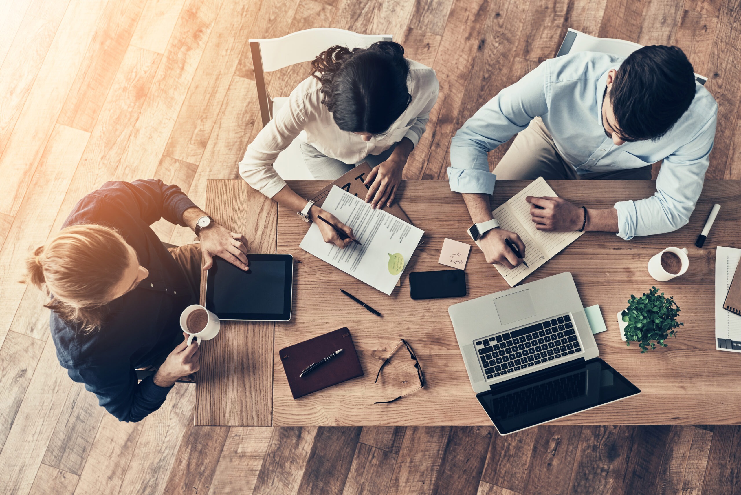 Paying attention to every detail. Top view of young modern colleagues in smart casual wear working together while spending time in the office